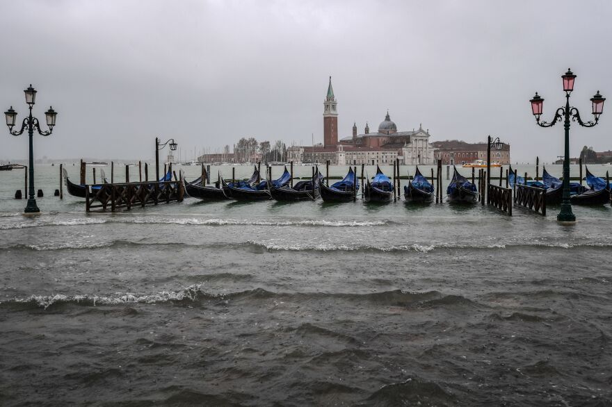 Gondolas are moored by the flooded Riva degli Schiavoni waterfront in Venice.