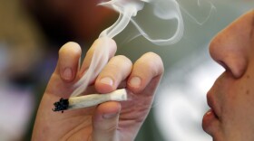 A man smokes a marijuana joint at a party celebrating weed on April 20, 2016, in Seattle.