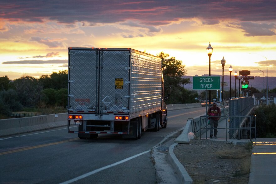 A semi truck travels west along Main Street and over the Green River at sunset in Green River, Utah, Aug. 18, 2024.