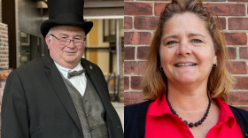 On the left is a man in a top hat and bow tie. On the right is a woman in a red shirt. 