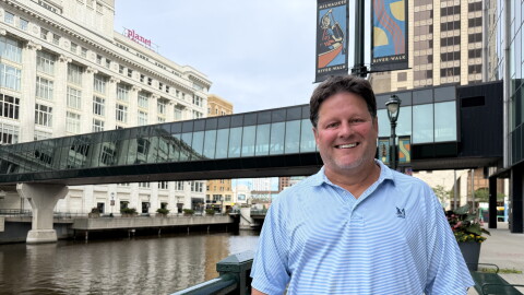 Retired Nicolet High School social studies teacher Mark Schill in front of the Milwaukee River in downtown Milwaukee, Wisconsin. 