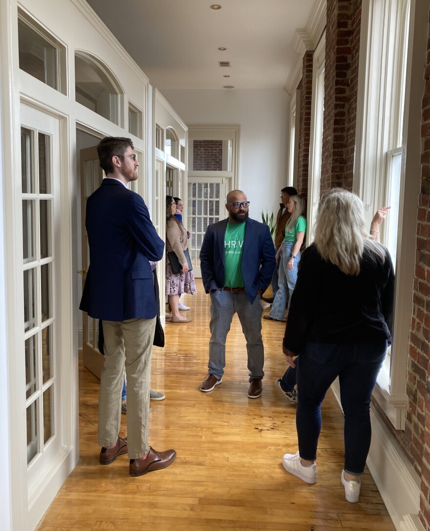 A group of people stand on hardwood floors inside Thrive's new community recovery location.