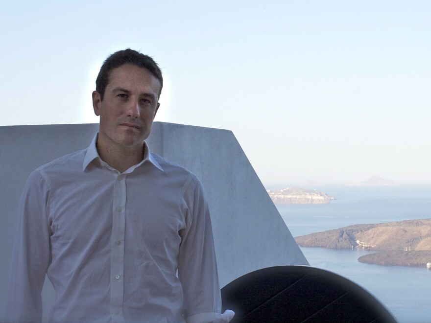 Peter Nomikos, who founded the charity Greece Debt Free about two weeks ago, sits outside the Santozeum, a family museum in Thira town, Santorini.