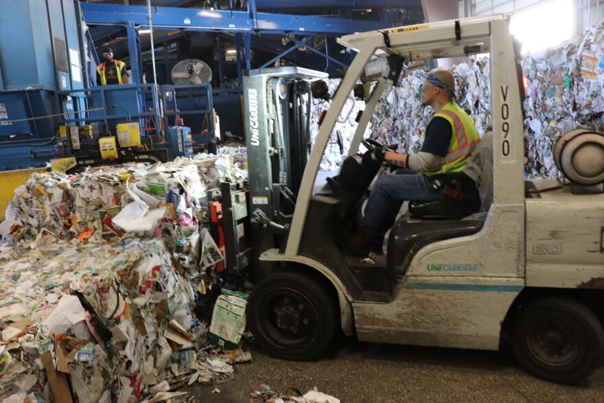 Man drving forklift at recycling plant