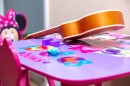 Nadia's Minnie mouse play table, with a small guitar on it.