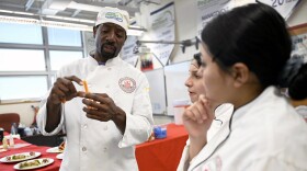 Wilbur Cross High School Culinary teacher Nathaniel Bradshaw reviews the cut size of carrots as his students practice for the National ProStart Invitational -- a competition where schools from all 50 states gather to compete in culinary arts and restaurant management skills. Bradshaw started the school's competitive culinary program around ten years ago, and has funded it through catering events and selling ice cream sandwiches during school.