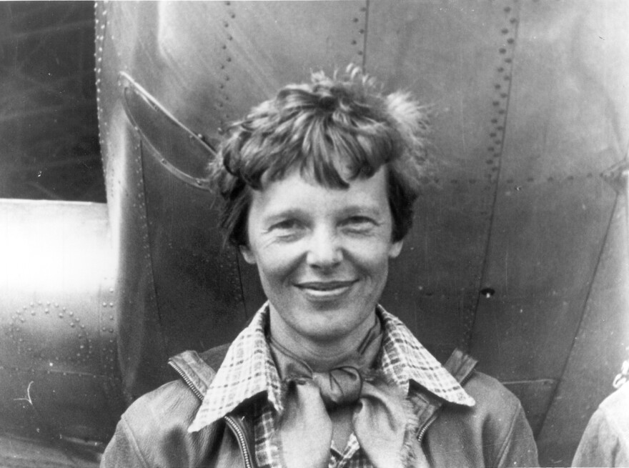 Amelia Earhart stands under the nose of her Lockheed Model 10-E Electra.