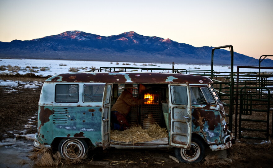 Dave Baker ignites a propane heater inside an old Volkwagen bus, preparing it as a shelter for the upcoming calving season.