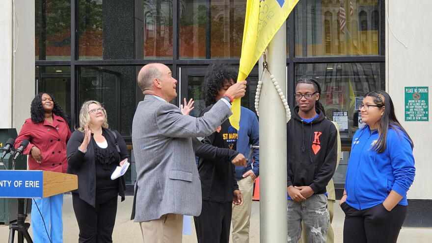  St. Mary's School for the Deaf students Yhindi Garcia, far right, Khyer Richardson, second from right, and Fahim Ahmed, behind flag, raise a flag for International Deaf Awareness Week with the help of Frank Cammarata, executive director for Erie County Office for People with Disabilities.