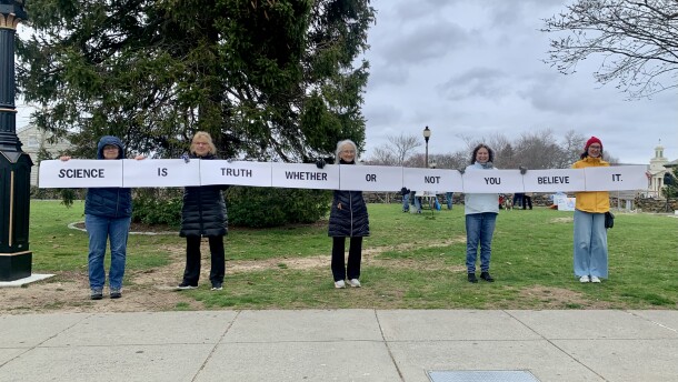 The Resister Sisters hold a sign at a rally in Falmouth to raise awareness about climate change. Laura Bergeron, center, says her group has met weekly since the second election of President Donald Trump.
