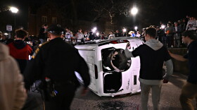 A flipped vehicle on UConn's campus in Storrs with a broken window with a lamp post through it that was taken down after UConn clinched the NCAA National Championship over SDSU on April 3, 2023.