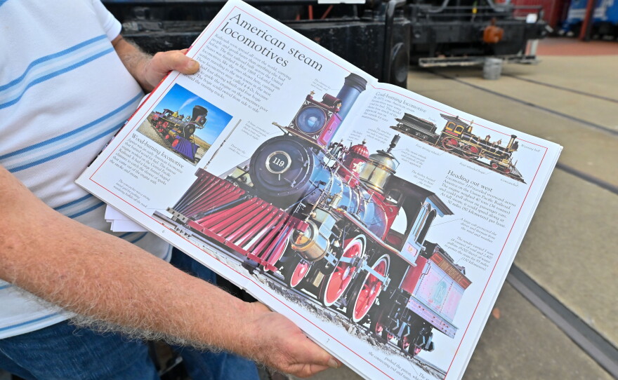 Dan Hryhorcoff holds a book that includes information on the Union Pacific 119.