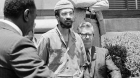 FILE - H. Rap Brown is escorted to a car by federal officers in New Orleans, June 2, 1972, after he was sentenced to five years in prison on a federal gun control conviction. Brown is also facing charges in New York in connection with a tavern holdup.