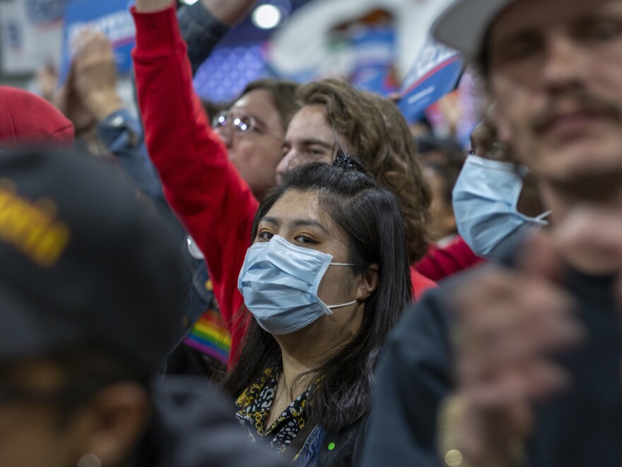 A woman in California wears a medical mask during a political campaign rally.