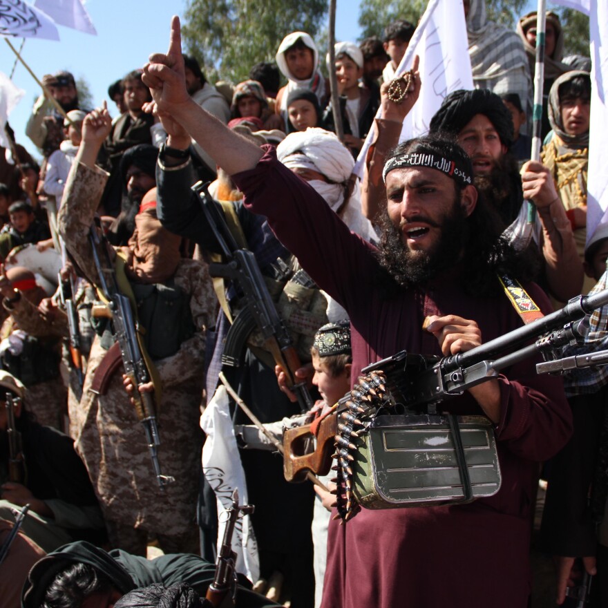 Afghan Taliban fighters and villagers attend a gathering in Laghman province, Alingar district, in March 2020 as they celebrate the peace deal signed between the U.S. and the Taliban. [Wali Sabawoon / NurPhoto via Getty Images]