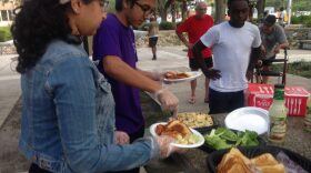 Samon Imtiaz and Raihan Noman prepare plates for those in need of a meal. If for some reason an individual is unable to wait in line, Project Downtown volunteers will personally deliver the food. Komal Junejo/ WUFT News