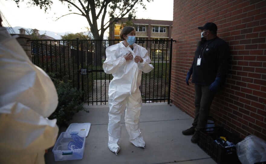 Colorado College mathematics professor Andrea Bruder suits up before descending into the tunnels below South Hall. Like so many faculty and staff members at U.S. colleges, she's redirected her research to focus on COVID-19.