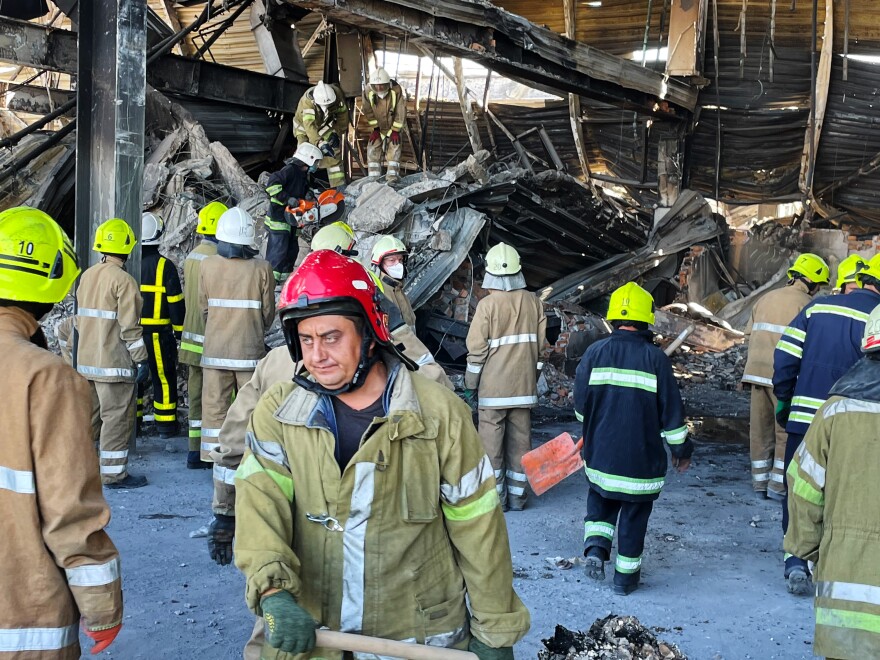 Workers clean up wreckage at the Amstor Mall in Kremenchuk, Ukraine, after the building was hit by a Russian cruise missile.