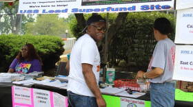 Ray Mosley works at the Community Advisory Group table with Akeeshea Daniels, left, and Maritza Lopez at Calumet Day, an annual block party. The CAG represents residents of the EPA-administered USS Lead Superfund site in East Chicago.