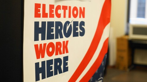 A closeup of a sign that reads "Election Heroes Work Here."