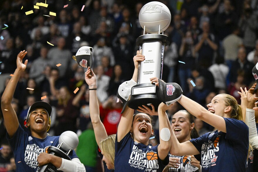 UConn Huskies forward Lou Lopez Senechal (11) and forward Dorka Juhasz (14) hoist the trophy next to UConn Huskies forward Aaliyah Edwards (3) after winning the Women's Big East Tournament title game overVillanova Wildcats on March 6, 2023, at Mohegan Sun Arena in Uncasville, CT.