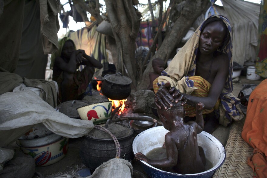 A woman from Chad washes her baby at a site for internally displaced persons. They had fled their village after an attack.