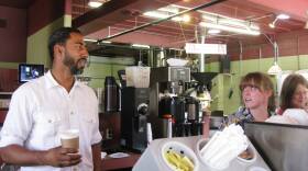 Jason Wilson, coffee in hand, talks with two of his workers at the Northwest Coffee Shop in the Central West End.