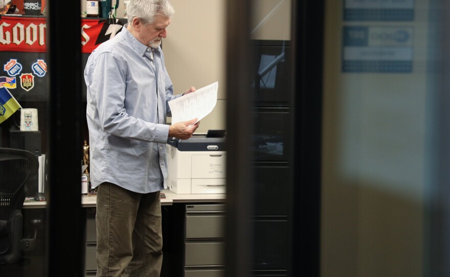 Alex Crichton checks some copy as he prepares to go on the air and host local breaks during NPR’s “All Things Considered” on WXXI News on Monday, Feb. 9, 2026. Crichton is retiring Feb. 27, 2026.