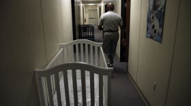 A federal employee walks past cribs inside of the barracks of a family detention center in Artesia, New Mexico, for those crossing the border. This photo is from 2014, when attorney Danielle Rosché volunteered there.