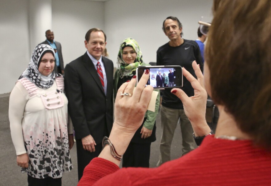 Basmah Alsaad, left, and Weam Alga asked Anna Crosslin, president and CEO of the Institute, right, foreground, to take a photo of them with St. Louis Mayor Francis Slay and their Institute English teacher, Les Meyer.