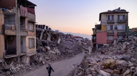 A man walks past collapsed buildings in Antakya, southern Turkey on Feb. 20, 2023. (Yasin Akgul/AFP via Getty Images)