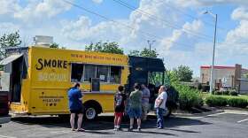 Exterior view of Smoke 'n' Seoul food truck with people waiting outside the truck.