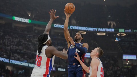 Cleveland Cavaliers' Donovan Mitchell, center, shoots between Detroit Pistons' Isaiah Stewart (28) and Duncan Robinson, right, in the first half of Game 4 of a second-round NBA basketball playoff series Monday, May 11, 2026, in Cleveland. 