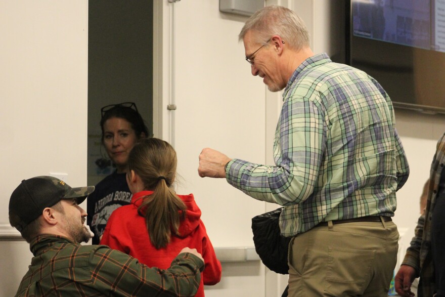 Aurora Borealis Charter School teacher Bill Severson (center) fist bumps an audience member after Kenai Peninsula Borough School District school board members approve a high school program for the school on Monday, Feb. 2, 2026 in Soldotna, Alaska.