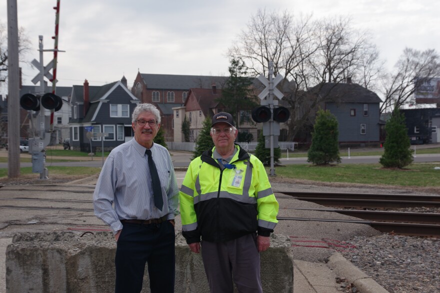 Kalamazoo Traffic Engineer Dennis Randolph and city resident James Voigt stand in front of a concrete barrier on Elm Crossover