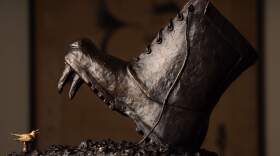 The boot features the fangs and snout of a Russian bear.  Nancy Schon, the 95-year-old sculptor best known for the iconic "Make Way for Ducklings" statue in the Boston Common, has created a new piece commenting on the horror in Ukraine. It depicts a Russian boot about to step down on a nightingale, the national bird of Ukraine. (Lane Turner/The Boston Globe via Getty Images)