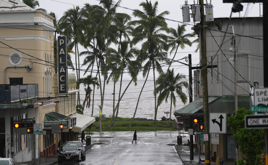A man crosses the road as Hurricane Nolo sits nearby Saturday, Sept. 26, 2026, in Hilo, Hawaiʻi.
