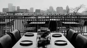 A table with place settings sits on a balcony overlooking the Milwaukee skyline.