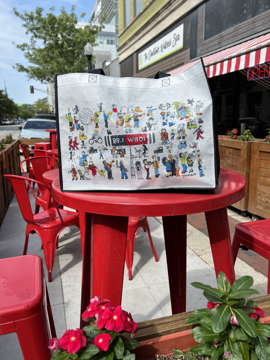 The black and white Community Waves bag on a red table.