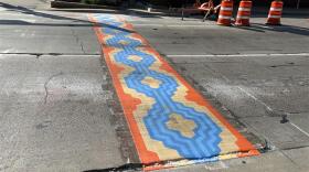 This crosswalk art is a part of a Sioux Falls-led initiative to encourage slower driving downtown.