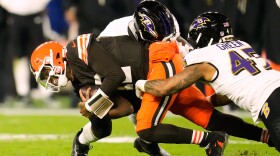 Cleveland Browns' Shedeur Sanders (12) is sacked by Baltimore Ravens' Roquan Smith, rear, and Mike Green (45) in the second half of an NFL football game in Cleveland, Sunday, Nov. 16, 2025. 