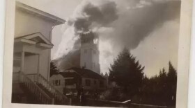 a grayscale photo of a church on fire