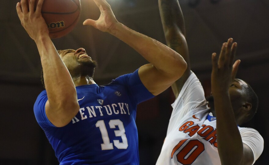 Kentucky’s Isaiah Briscoe (13) goes up hard against Florida’s Dorian Finney-Smith (10) for a layup in the first half. (Greenberry Taylor/WUFT News)