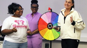 Nicole Miller, left, founder of Blossoming Butterfly Inc., on stage with a member of STOP Cancer, asking the group trivia questions about her presentation. (Catherine Chapman/WUFT News)