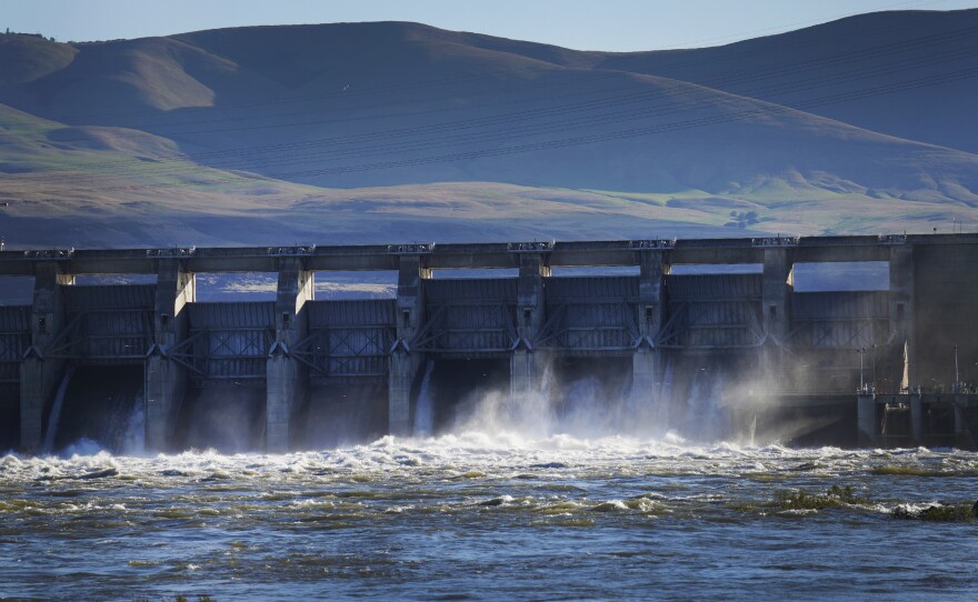 Water flows over The Dalles Dam on the Columbia River as seen from The Dalles, Ore., on Sunday, June 19, 2022. Hydroelectric dams, like The Dalles Dam, on the Columbia and its tributaries have curtailed the river's flow, further imperiling salmon migration from the Pacific Ocean to their freshwater spawning grounds upstream.