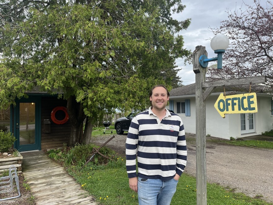 George Brittain, standing outside the office of the Anchor Inn on West Bay in Traverse City. It’s a remodeled historic motel, just across the road from the beach. (Photo: Claire Keenan-Kurgan/IPR News)