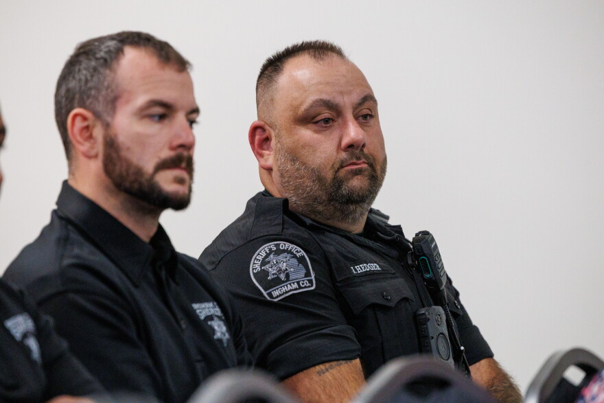 Ingham County Sheriff's Deputy Jason Hedger, right, sitting next to another deputy.