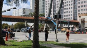 Pedestrians wait to cross Southwest Eighth Street. Johane Saintil