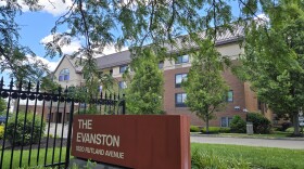 A large apartment building behind a sign reading "The Evanston."
