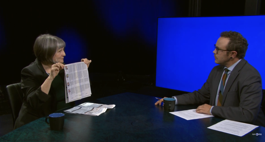 President of the League of Women Voters of New Mexico Hannah Burling shows Nash Jones a copy of the League's voter guide for Santa Fe County. Find your guide at Vote411.org.
